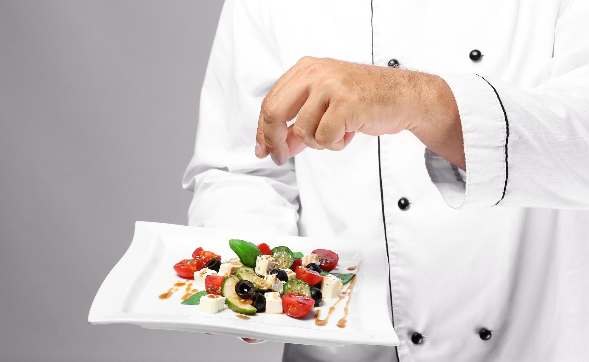 Instructor demonstrating plating technique in modern kitchen